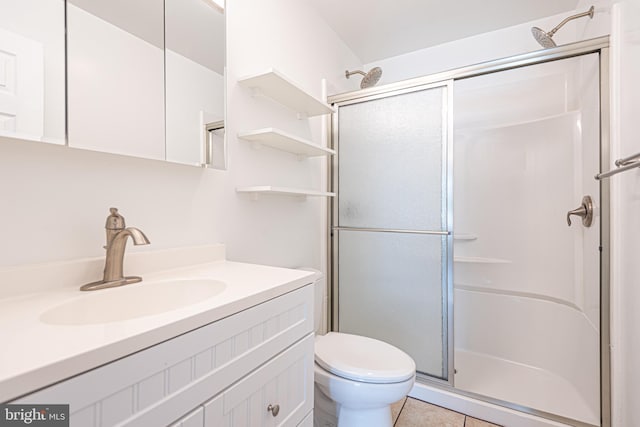 bathroom with tile patterned flooring, a shower with door, toilet, and vanity