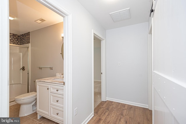 bathroom with walk in shower, wood-type flooring, vanity, and toilet