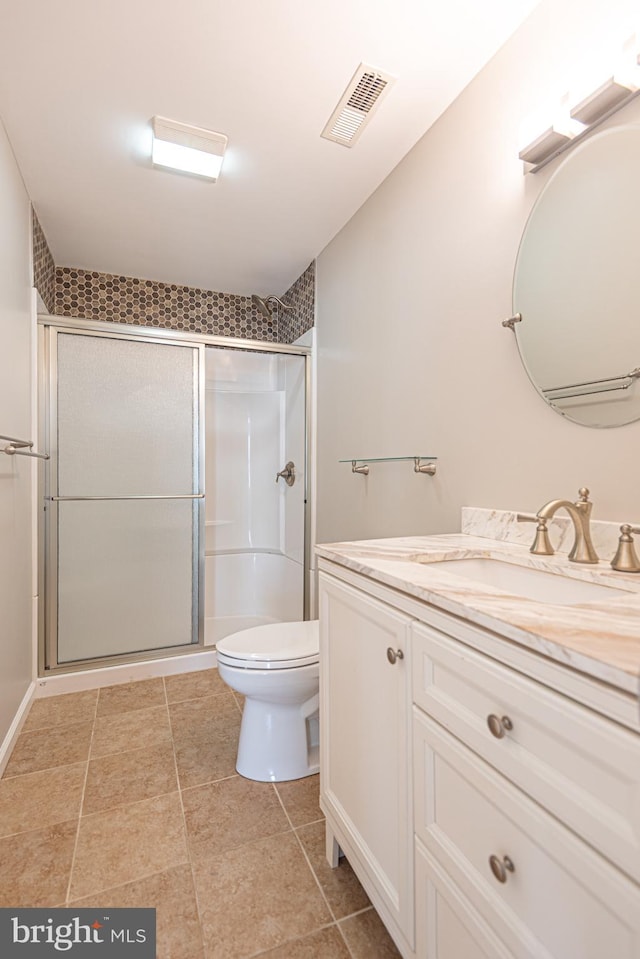 bathroom featuring tile patterned flooring, vanity, toilet, and an enclosed shower