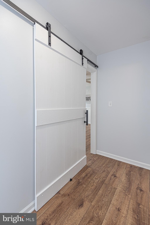 unfurnished room featuring hardwood / wood-style floors and a barn door