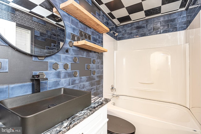 full bathroom featuring tile walls, shower / bathtub combination, tasteful backsplash, vanity, and toilet