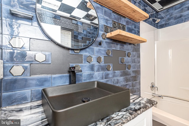 bathroom with shower / bathtub combination, vanity, and tasteful backsplash