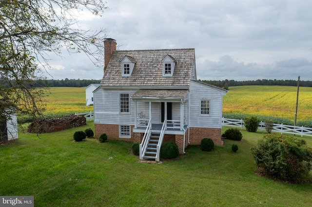 rear view of property with a rural view and a lawn