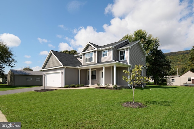 view of front facade featuring a front yard, a garage, and covered porch