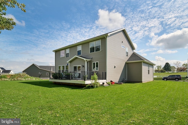 back of house featuring a lawn and a wooden deck