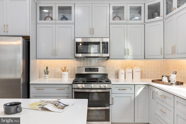 kitchen featuring stainless steel appliances and tasteful backsplash