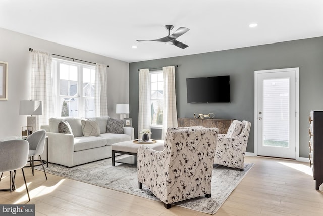 living room featuring ceiling fan and light hardwood / wood-style flooring