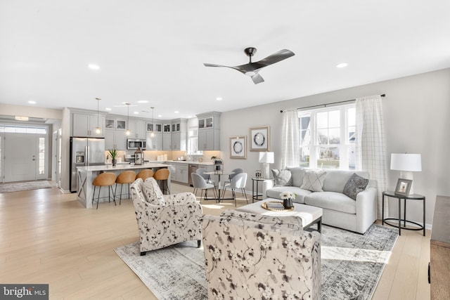 living room with light hardwood / wood-style floors and ceiling fan