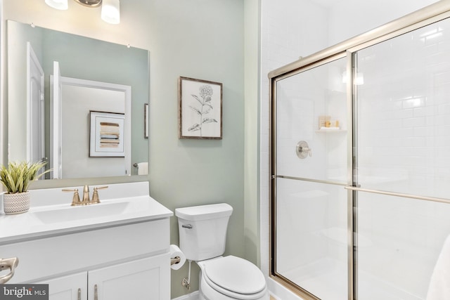 bathroom featuring vanity, toilet, and an enclosed shower