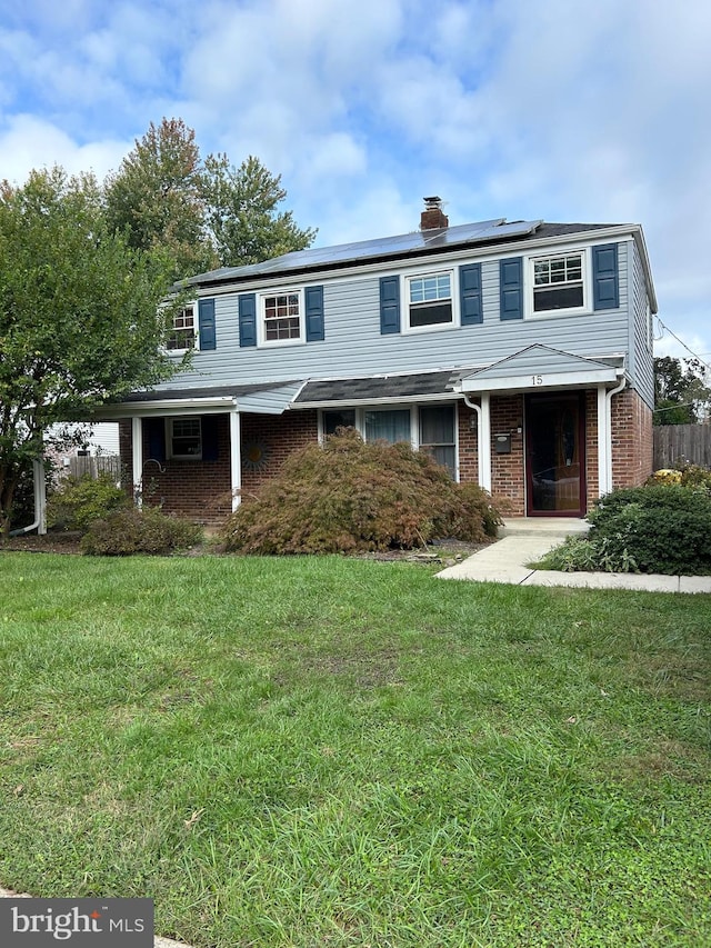 front facade featuring solar panels and a front lawn