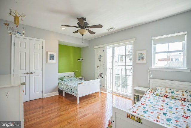 bedroom with ceiling fan, a closet, and light hardwood / wood-style floors