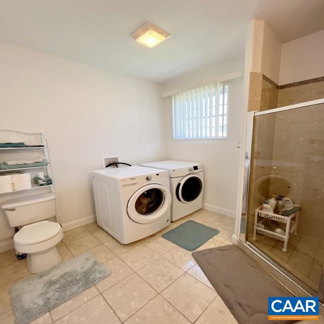 laundry room featuring separate washer and dryer and light tile patterned floors