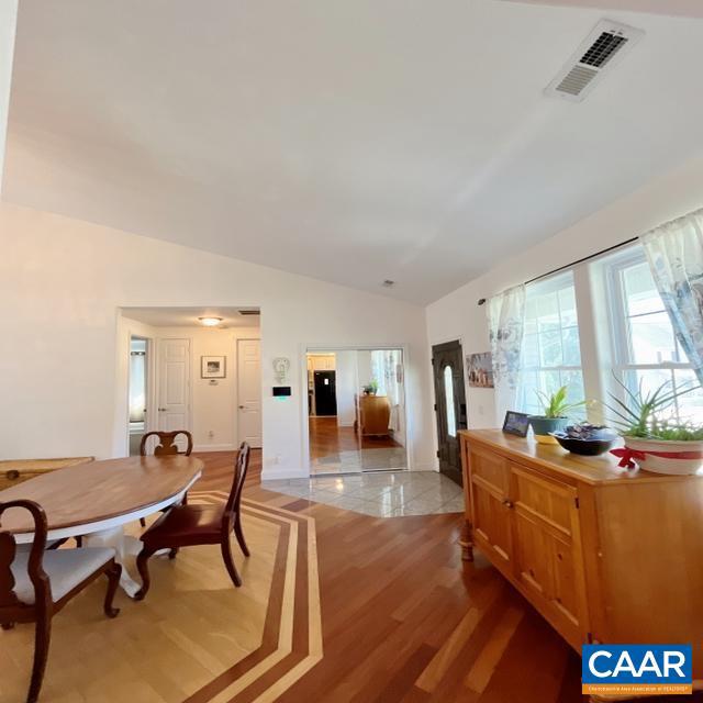 dining room with light hardwood / wood-style floors and vaulted ceiling