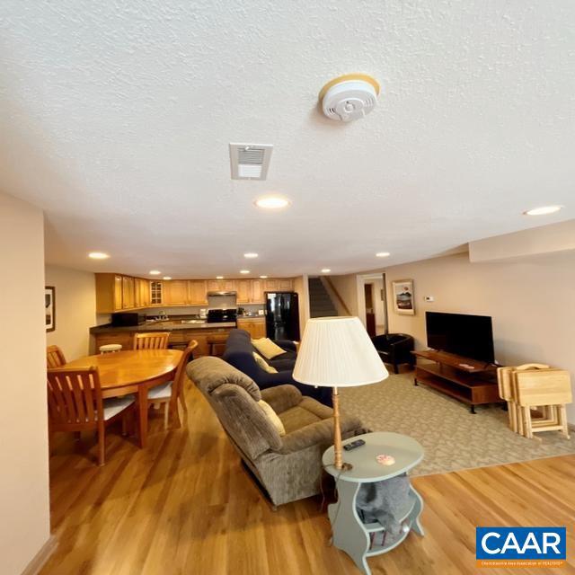 living room with a textured ceiling and light hardwood / wood-style flooring