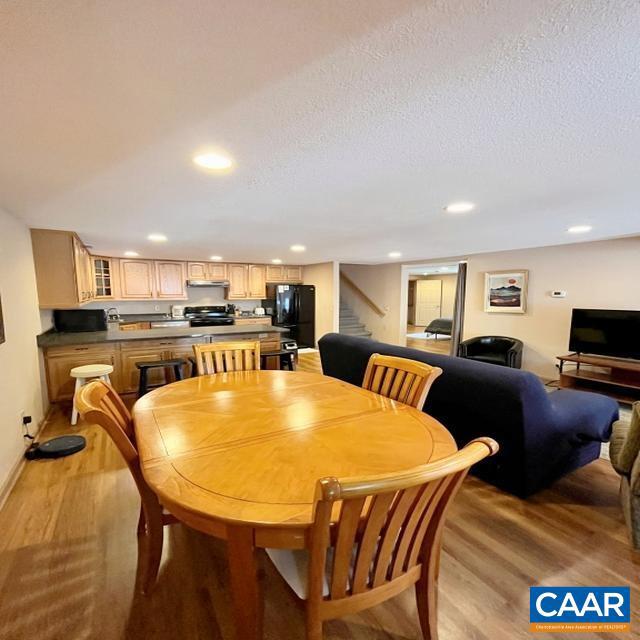 dining area featuring light hardwood / wood-style flooring and a textured ceiling