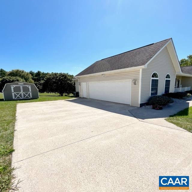 view of side of home featuring a storage shed and a garage