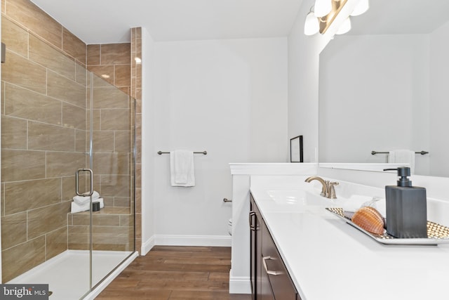 bathroom with vanity, toilet, wood-type flooring, and a shower with door