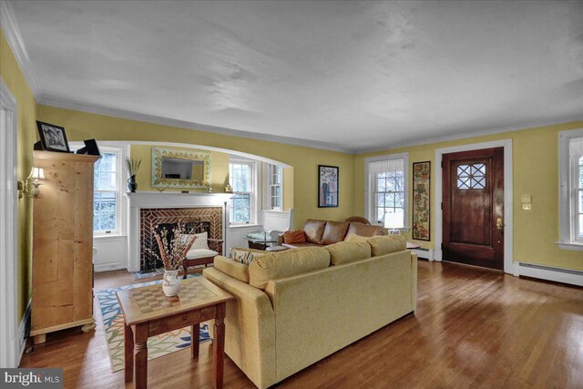 living room with wood-type flooring, ornamental molding, a chandelier, and plenty of natural light