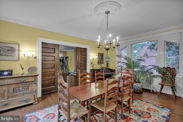 dining room with dark hardwood / wood-style floors, ornamental molding, and a chandelier