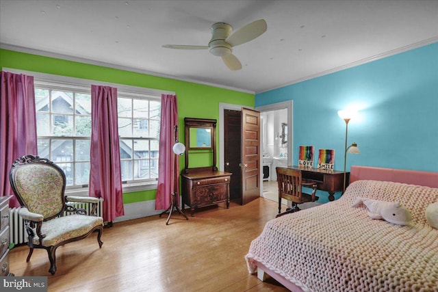 bedroom featuring light hardwood / wood-style floors, ceiling fan, ensuite bath, and crown molding