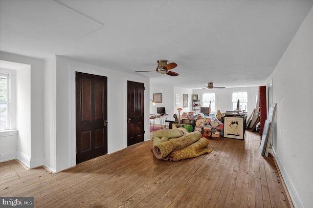 living room featuring ceiling fan, light wood-type flooring, and a healthy amount of sunlight