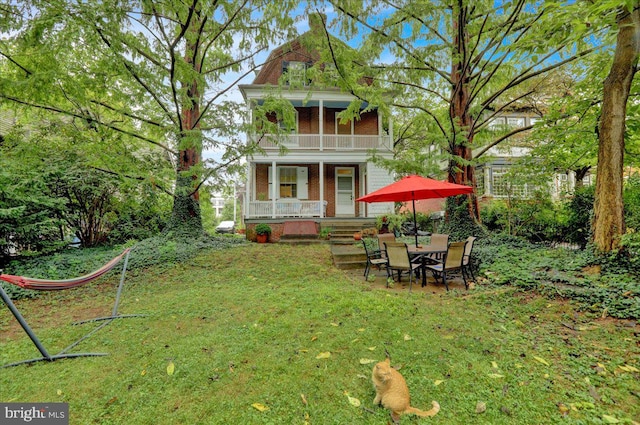 view of yard featuring a balcony and a patio