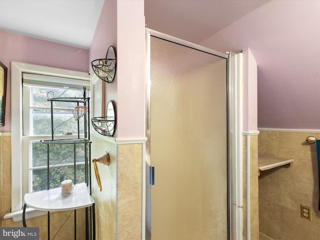 bathroom with walk in shower and tile walls