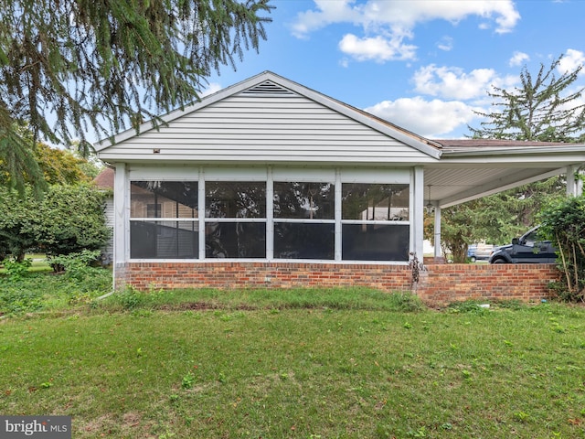 view of property exterior featuring a yard and a sunroom