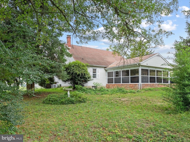 back of house featuring a yard and a sunroom