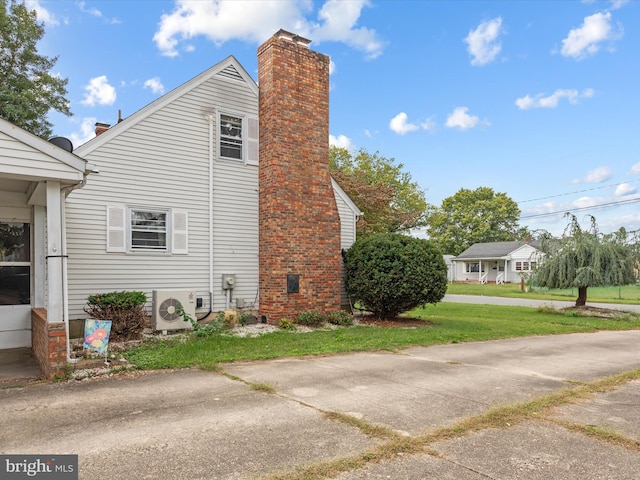 view of property exterior featuring ac unit and a yard