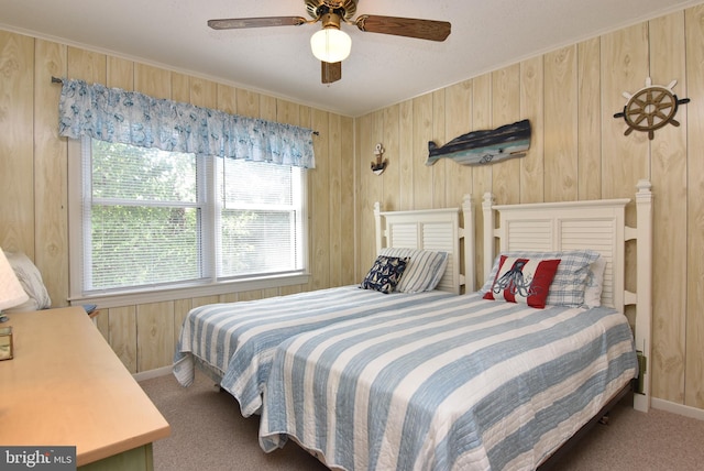 bedroom featuring ceiling fan, carpet floors, and wooden walls