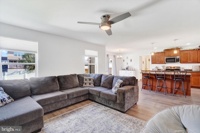 living room with ceiling fan and light hardwood / wood-style floors