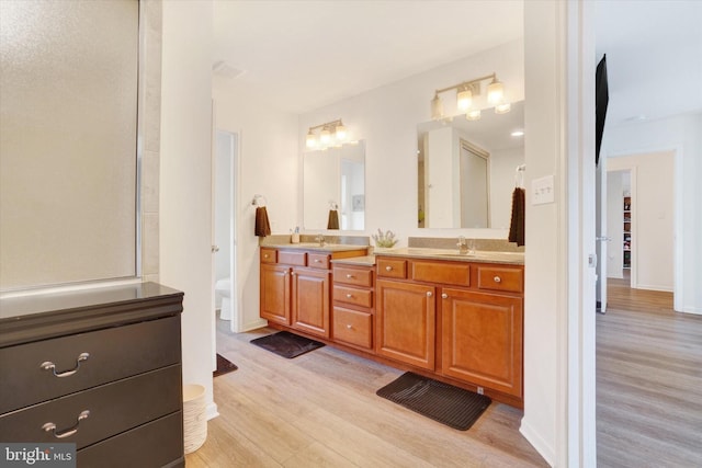 bathroom with hardwood / wood-style flooring, toilet, and vanity