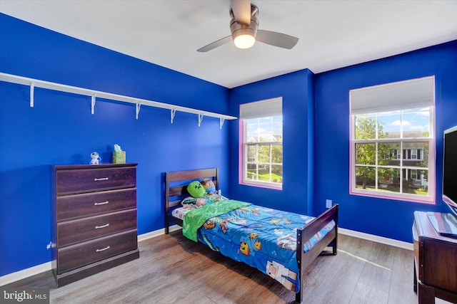 bedroom with ceiling fan and light hardwood / wood-style floors