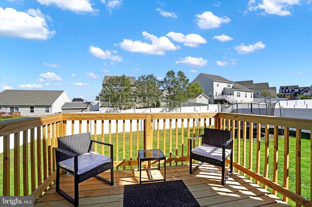 wooden terrace featuring a lawn