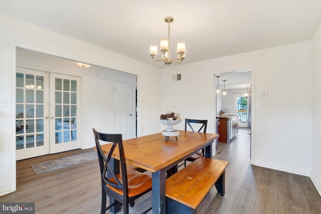 dining room with an inviting chandelier and dark hardwood / wood-style flooring