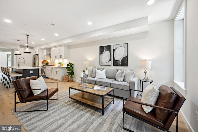 living room featuring light hardwood / wood-style floors and sink