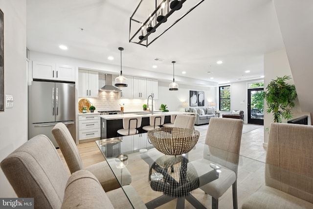 dining room with light wood-type flooring, an inviting chandelier, and sink