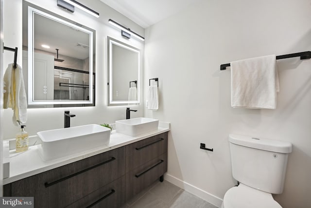 bathroom featuring vanity, a shower with shower door, toilet, and tile patterned floors