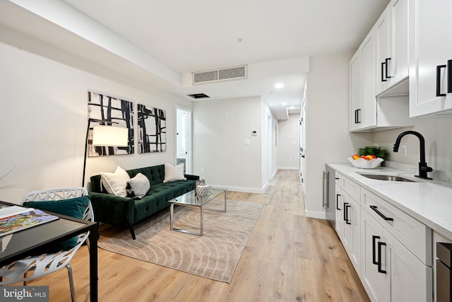 living room with light hardwood / wood-style flooring and sink