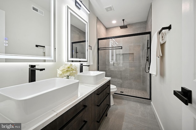 bathroom with tile patterned flooring, a shower with door, vanity, and toilet