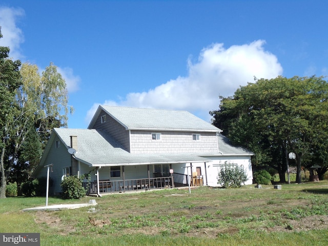 rear view of property with a yard and covered porch