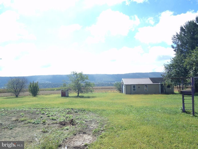 view of yard with a mountain view and a rural view