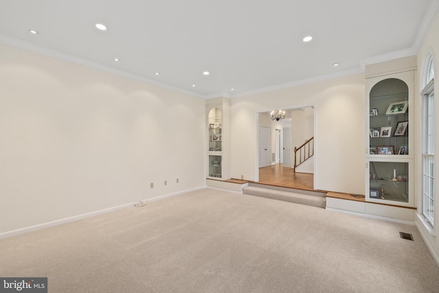 unfurnished room with light carpet, a notable chandelier, and ornamental molding