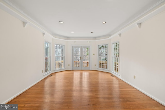 unfurnished room featuring light hardwood / wood-style floors, ornamental molding, and french doors