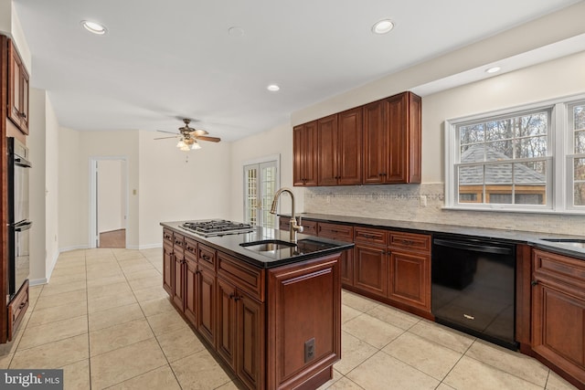 kitchen featuring dishwasher, ceiling fan, an island with sink, tasteful backsplash, and light tile patterned flooring