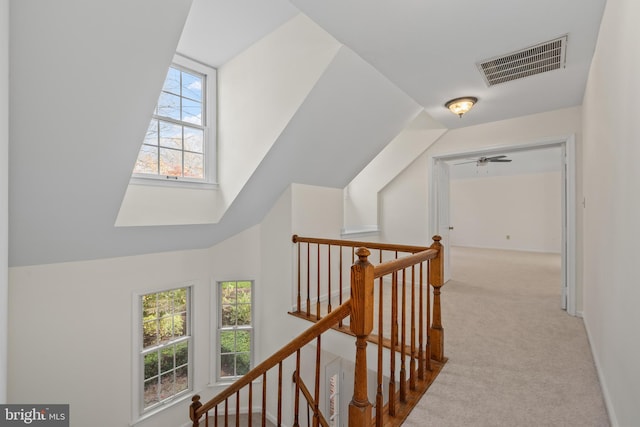 hall featuring lofted ceiling, carpet floors, and a healthy amount of sunlight