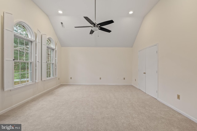 spare room with ceiling fan, light colored carpet, and lofted ceiling