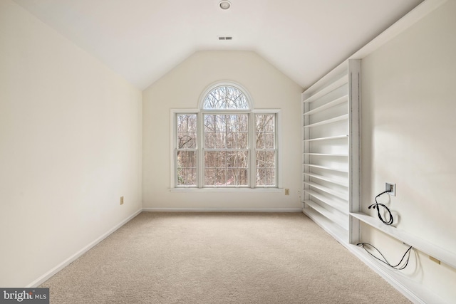 carpeted spare room featuring lofted ceiling