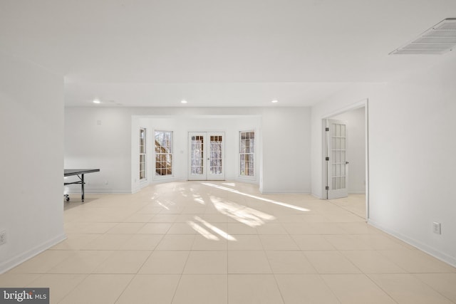 tiled empty room featuring french doors